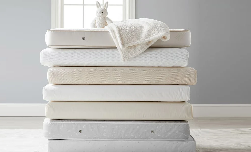 assorted crib mattresses stacked atop one another