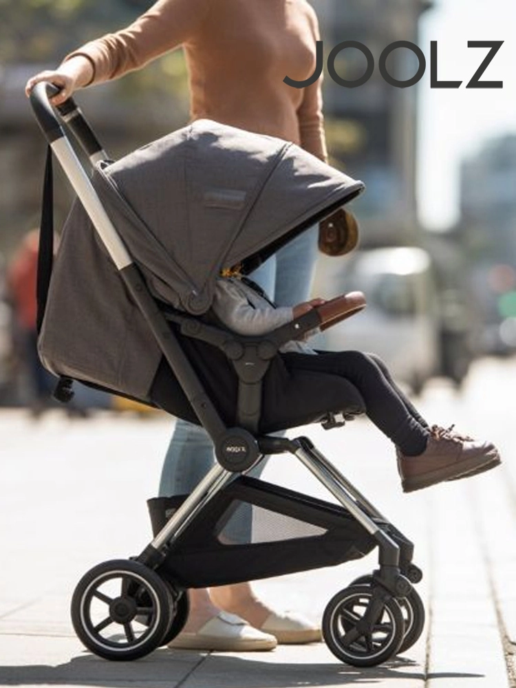 a woman pushing a joolz aer stroller against an urban background
