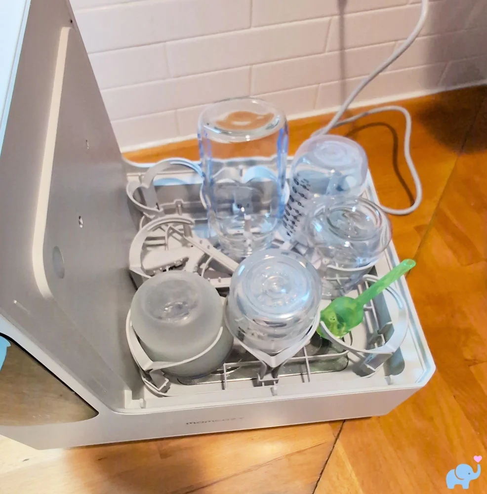 Bottom rack of the Momcozy DeepClean Baby Bottle Washer D8 loaded with five baby bottles
