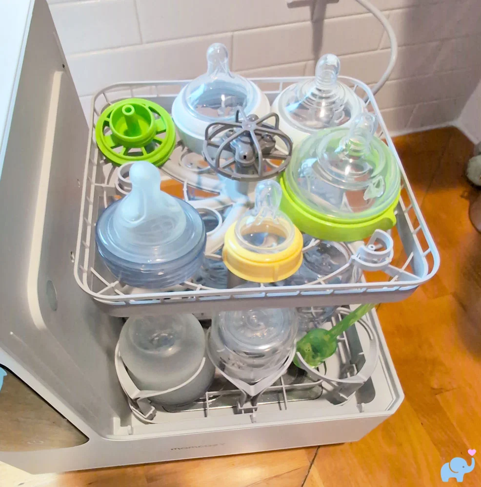 Upper rack of the Momcozy DeepClean Baby Bottle Washer D8 loaded with nipples and bottle parts