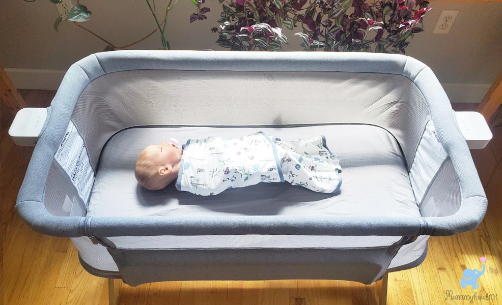 a baby sleeping in the newton bassinet