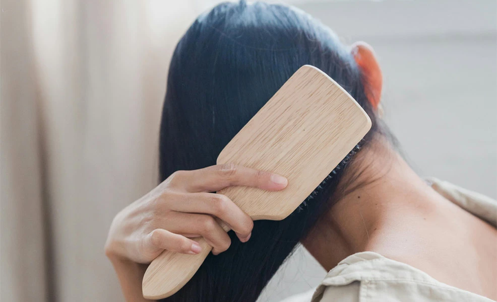 a pregnant woman with hair loss visible on a brush